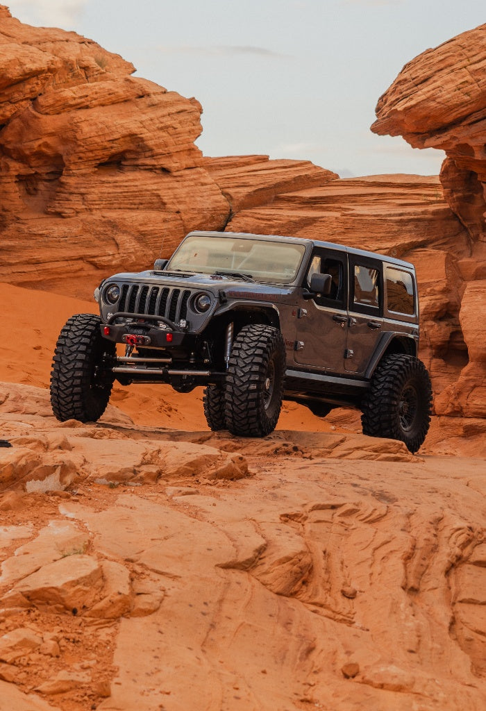 Nemesis Industries Jeep Wrangler JL Unlimited with extreme lift and 40-inch tires navigating Utah rock formations