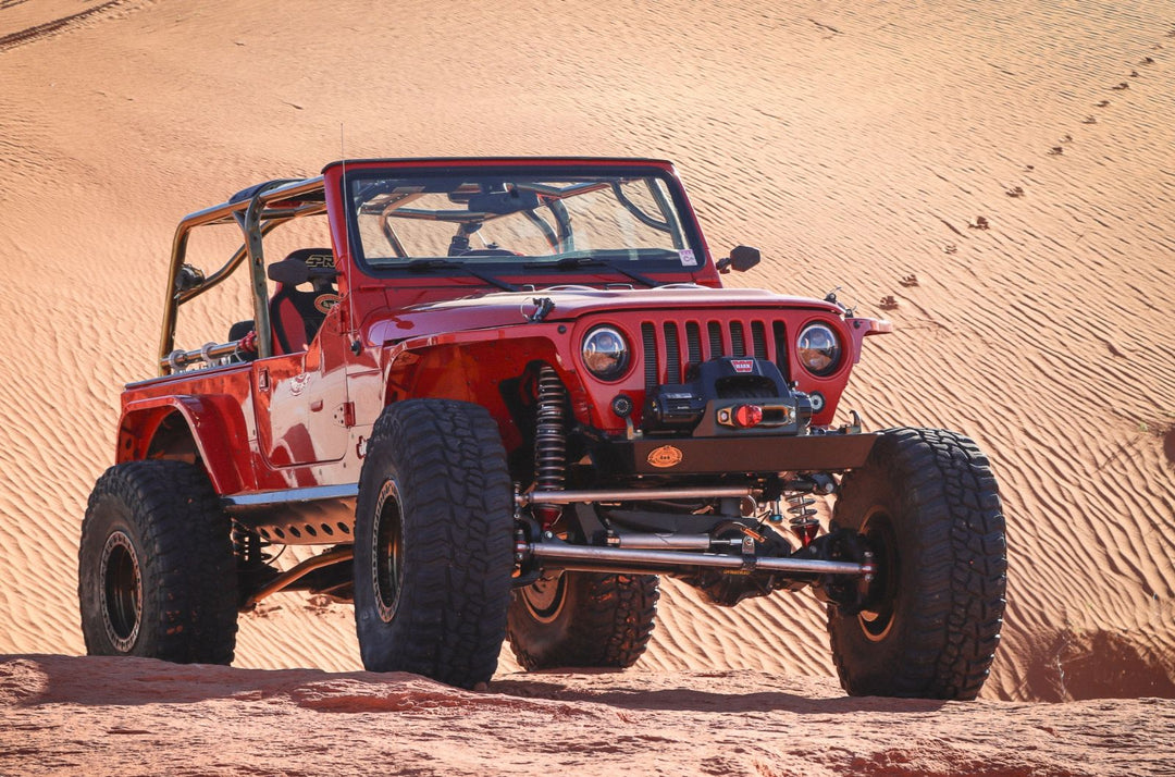 Nemesis Industries Jeep Wrangler TJ with Warn winch and long-arm suspension on red sand dunes — desert wheeling