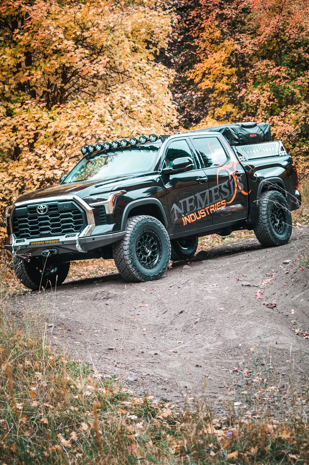 Nemesis Industries Toyota Tundra 3rd gen with bed rack, rooftop tent, and LED light bar — overland build